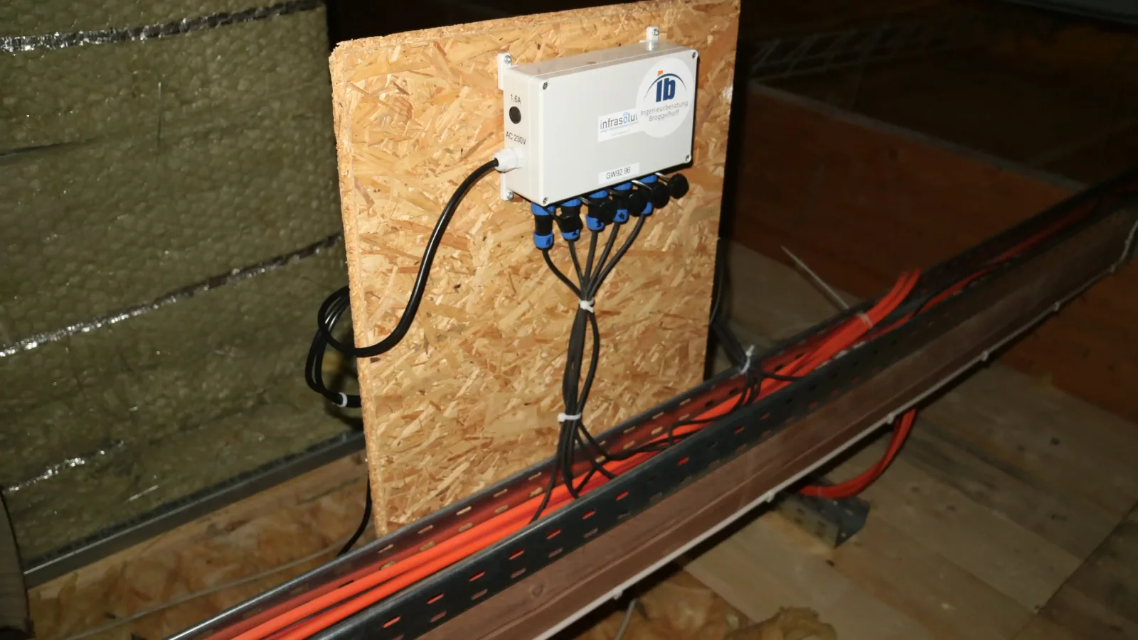 Gateway im Dachraum, montiert auf einer Holzplatte, mit fünf angeschlossenen Sensorkabeln und der Kennzeichnung AC 230V